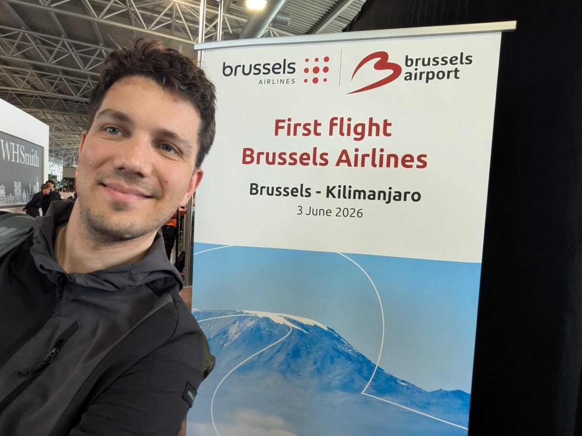 Maciek przy banerze „First flight Brussels Airlines Brussels – Kilimanjaro” na lotnisku w Brukseli