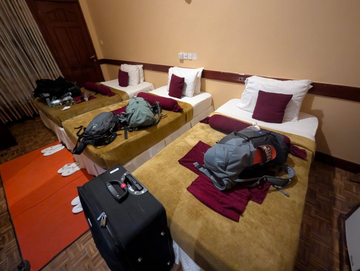Pokój hotelowy w Aruszy z trzema łóżkami i naszymi plecakami