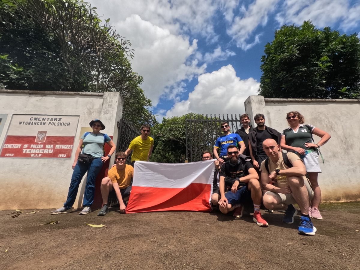 Nasza grupa z polską flagą przed bramą Cmentarza Wygnańców Polskich w Tengeru