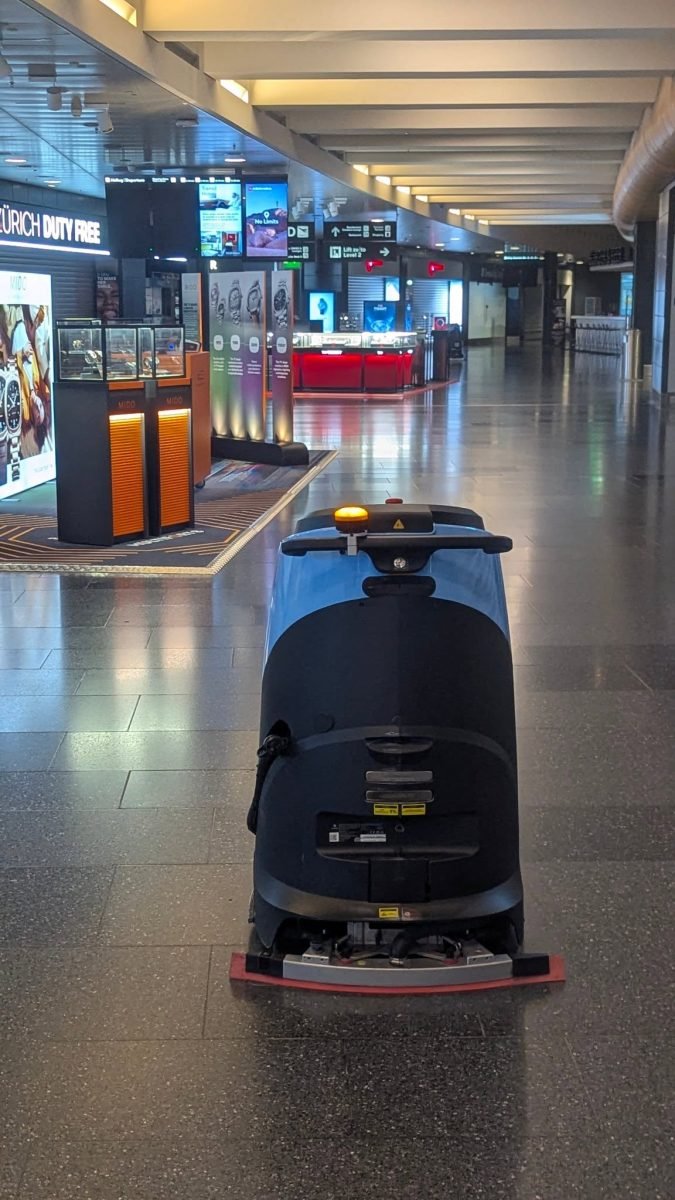 Robot czyszczący podłogi w nocnej hali lotniska w Zurychu