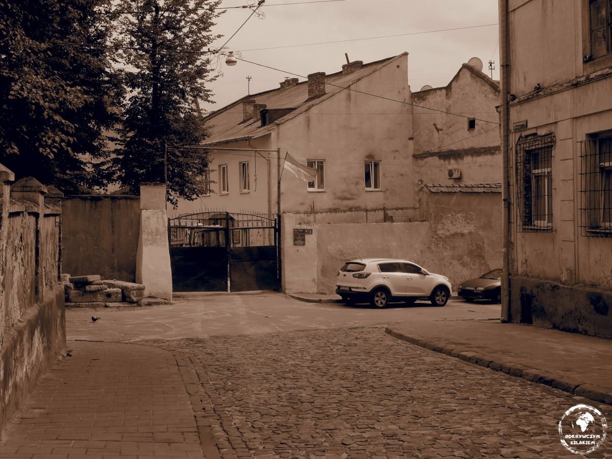Stare podwórze z bramą i kamienicami na lwowskim starym mieście (zdjęcie w sepii)