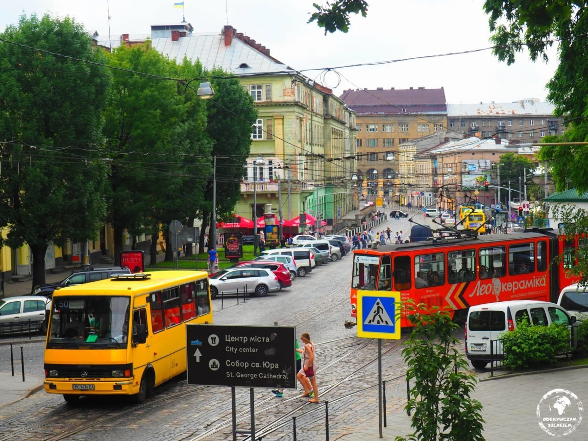 Tramwaj i żółta marszrutka na ulicy we Lwowie, w tle kamienice starego miasta