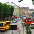 Tramwaj i żółta marszrutka na ulicy we Lwowie, w tle kamienice starego miasta