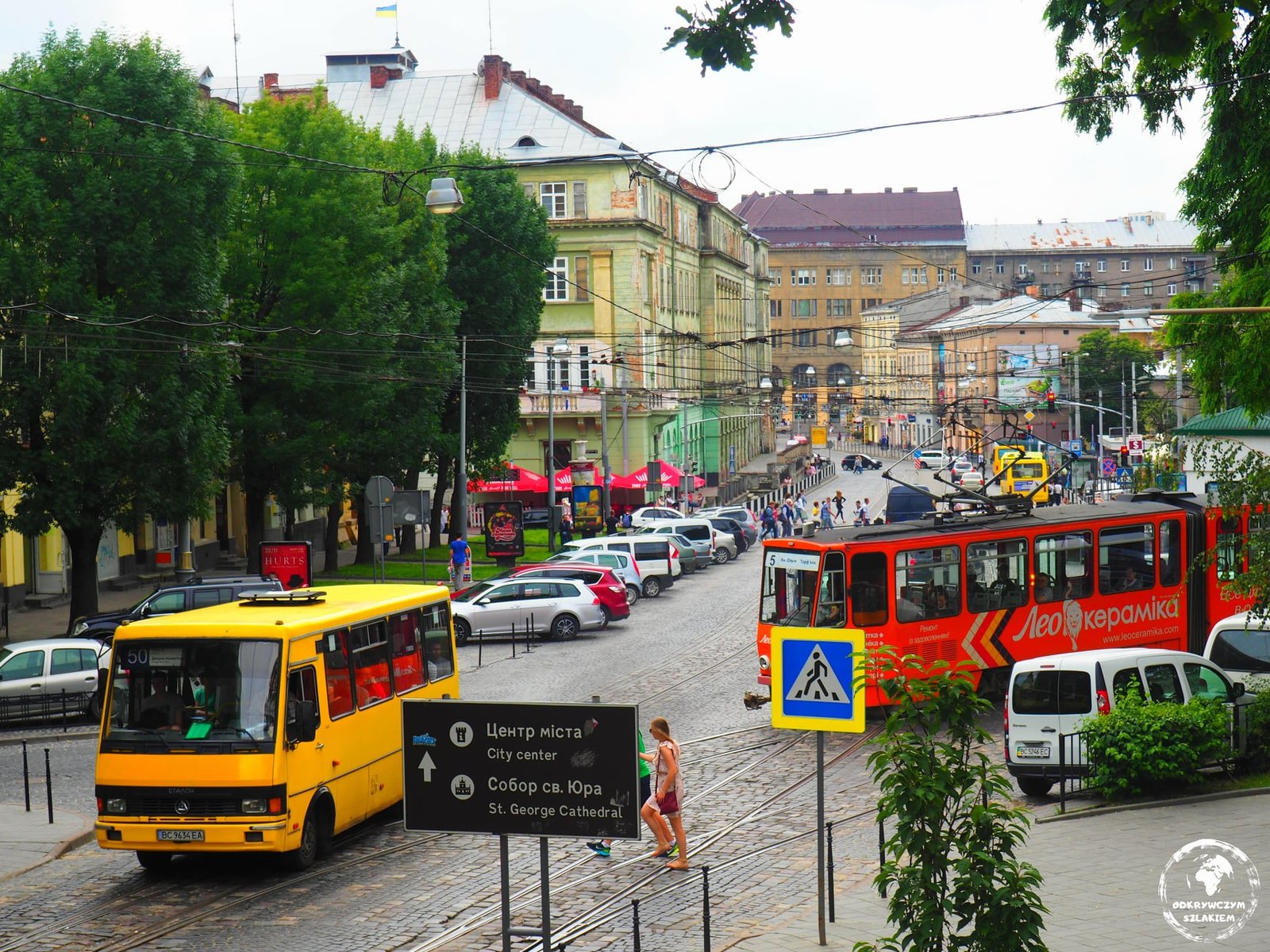 Tramwaj i żółta marszrutka na ulicy we Lwowie, w tle kamienice starego miasta