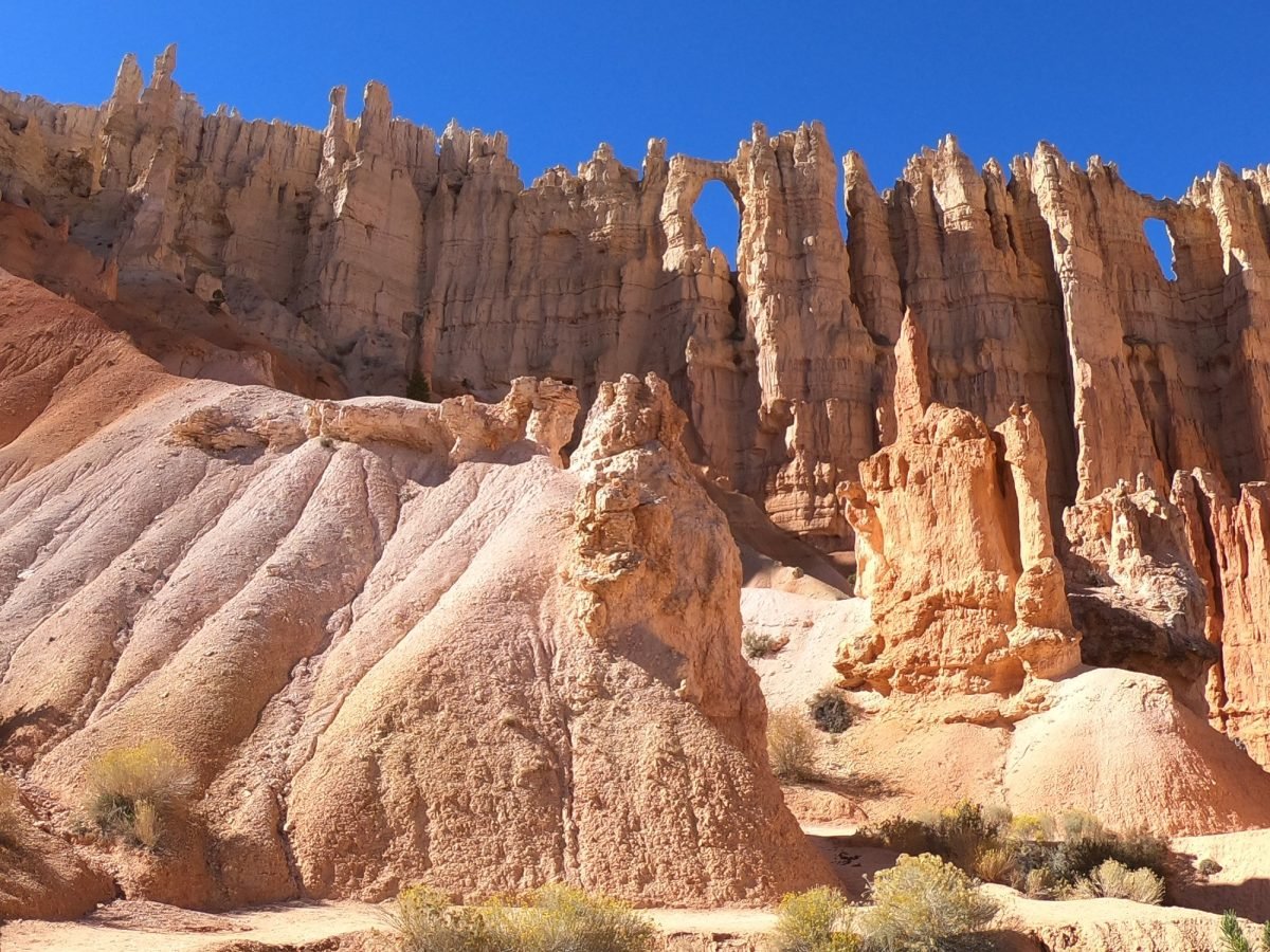 Skalna ściana z oknami i jasne iglice w Bryce Canyon