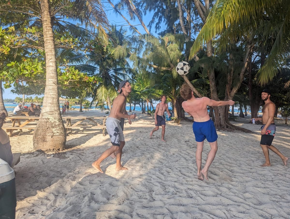 Gra w piłkę na piaszczystej plaży pod palmami na Water Cay