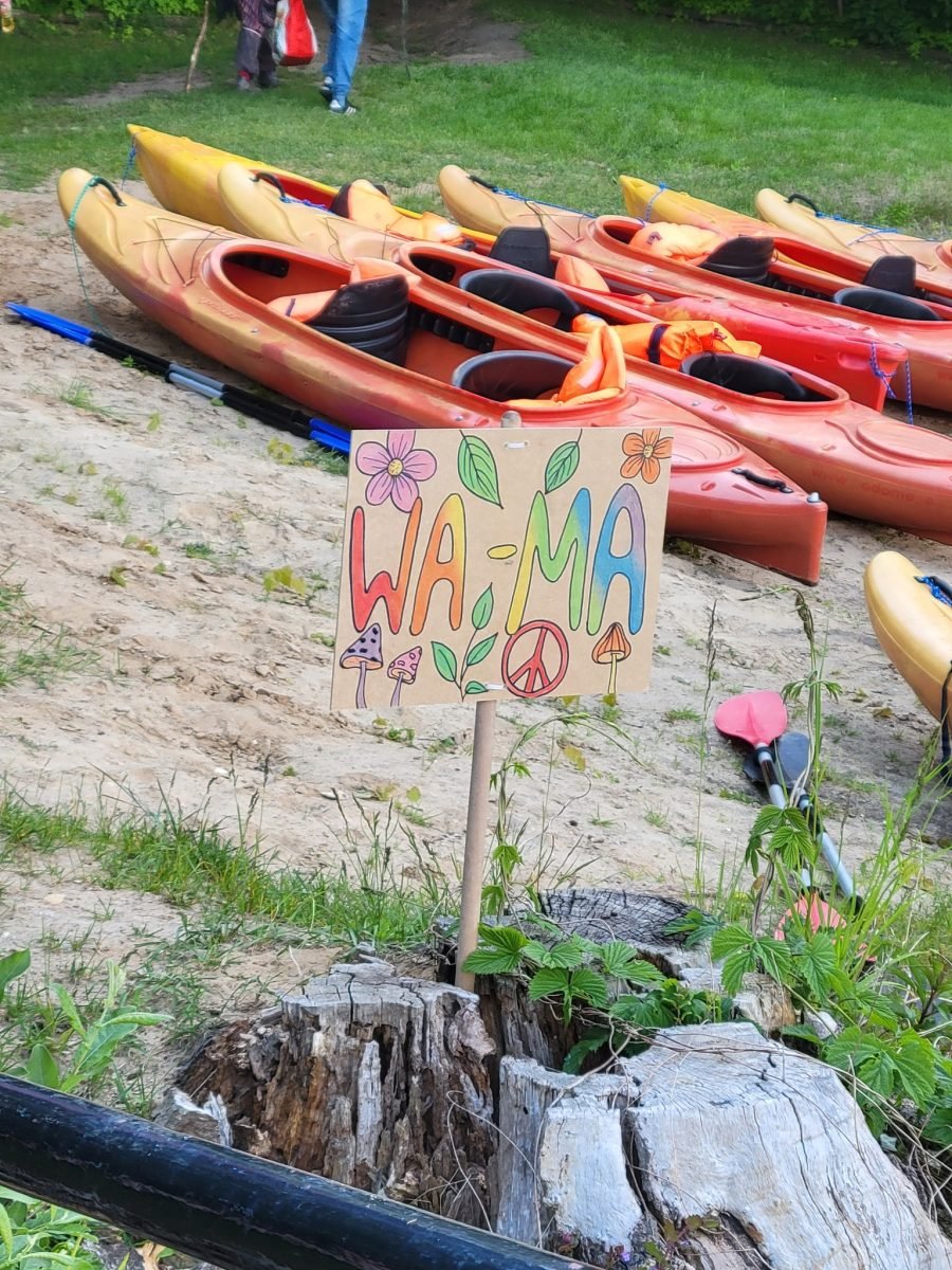 Kolorowa tabliczka z napisem WA-MA przy kajakach na plaży ośrodka na Wielkiej Żuławie