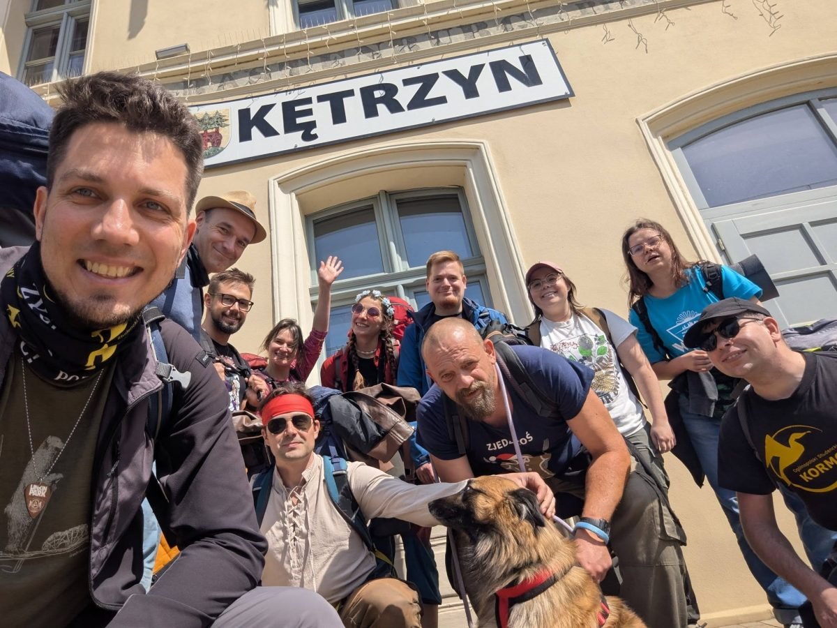 Maciek z uczestnikami trasy „Twardziele” przed dworcem kolejowym w Kętrzynie