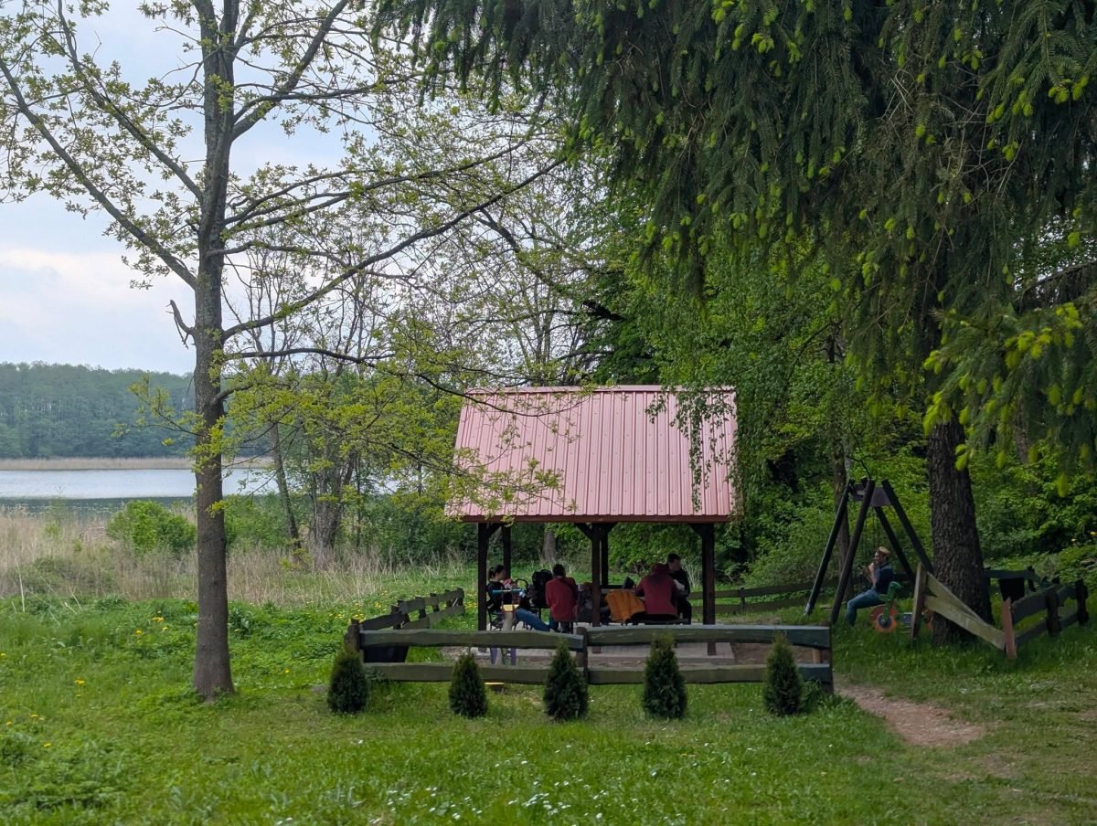 Wiata z czerwonym dachem nad jeziorem w stanicy w Kietlicach