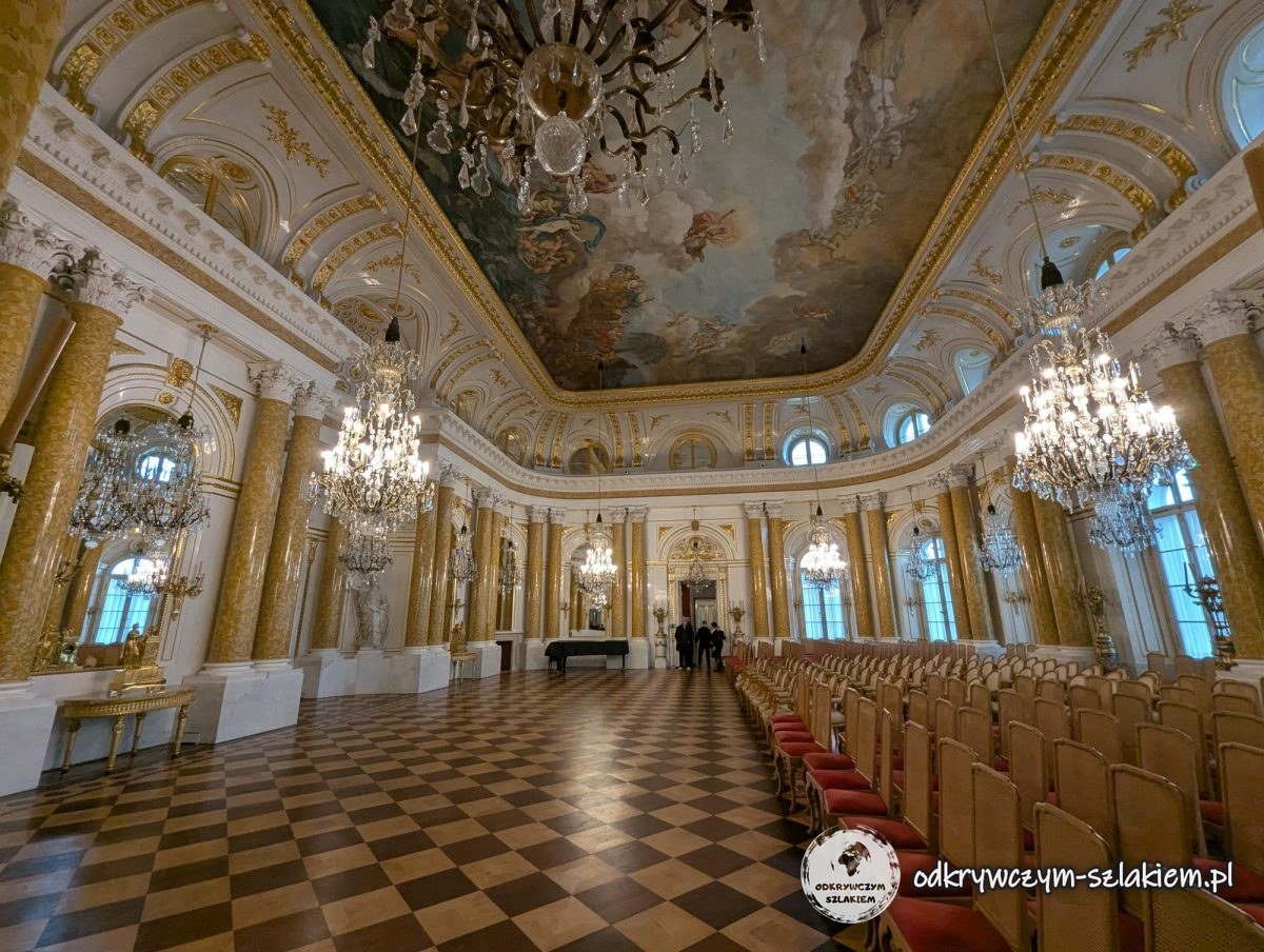 El Gran Salón del Castillo Real de Varsovia con columnas doradas, lámparas de araña y techo pintado