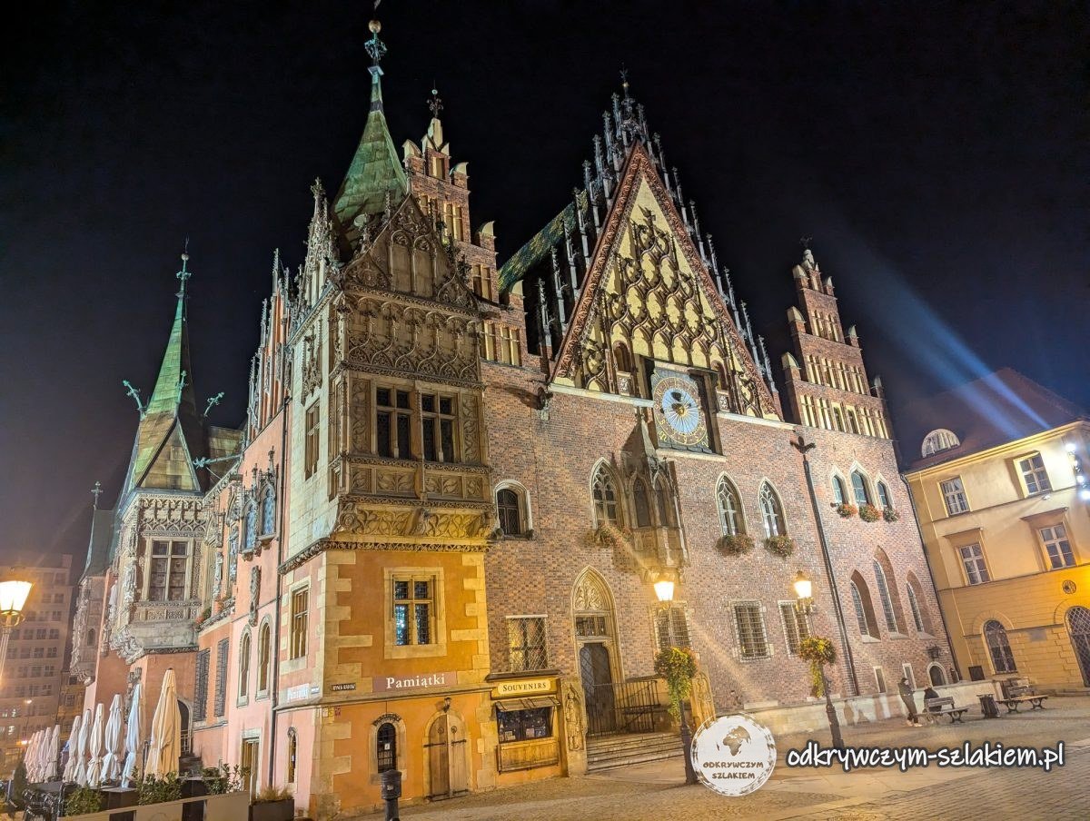 Wschodnia fasada Ratusza we Wrocławiu z ozdobnym szczytem i zegarem, podświetlona po północy
