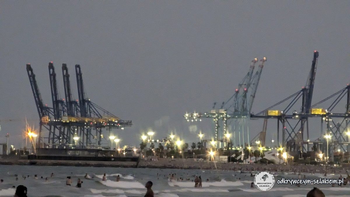 Żurawie portowe w Walencji widziane z plaży wieczorem