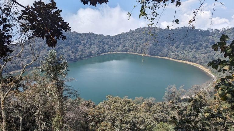 Laguna Chicabal w zalesionym kraterze wulkanu widziana z punktu widokowego