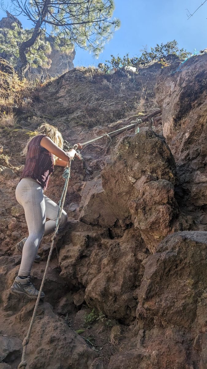 Patrycja wspina się po stromej skale z pomocą liny na Cerro Quemado