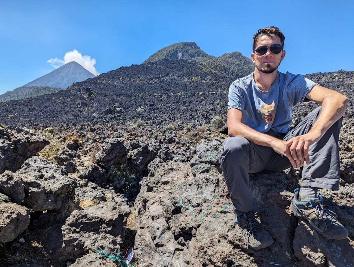 Maciek na polu lawy Cerro Quemado, w tle stożek wulkanu Santa María