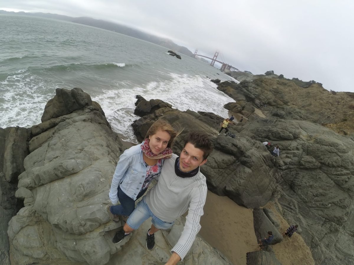 Na skałach nad oceanem przy Baker Beach w San Francisco, w oddali most Golden Gate