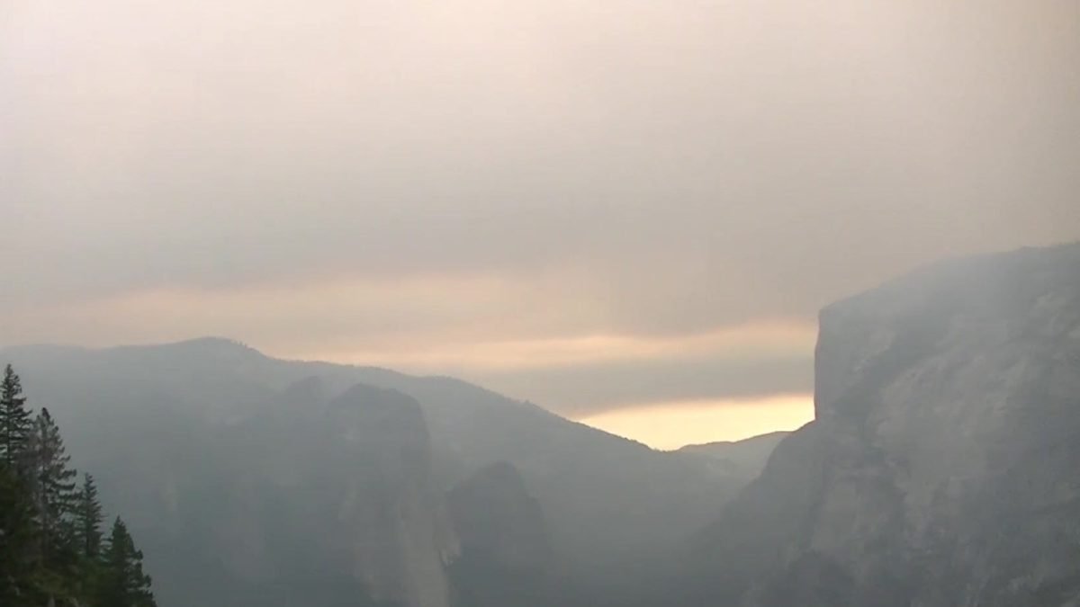 Dolina Yosemite i granitowe ściany w dymie z pożaru Ferguson Fire o zachodzie słońca