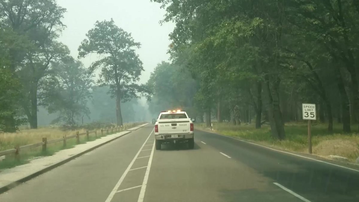 Konwój ewakuacyjny z Yosemite za samochodem strażników parku, w dymie z pożaru