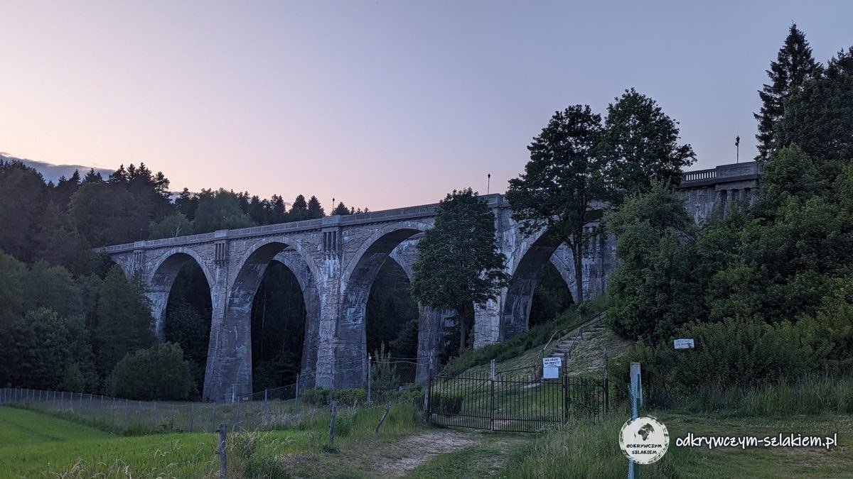 Ein Eisenbahnviadukt aus Beton mit hohen Bögen in Stańczyki in der Dämmerung
